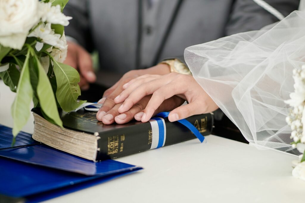 Photo by Job Ferrari of a wedding couple joining hands atop a Bible.